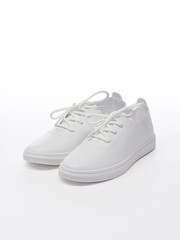 Pair of leather sport shoes on a white background. Isolated white sneakers with shadow