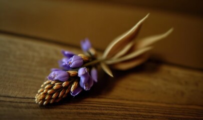  a close up of a purple flower on a wooden surface with a blurry background of wood grain and a single flower bud on the end of the stem.  generative ai
