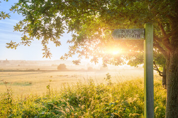 Obraz premium Spring countryside sunrise and public footpath sign