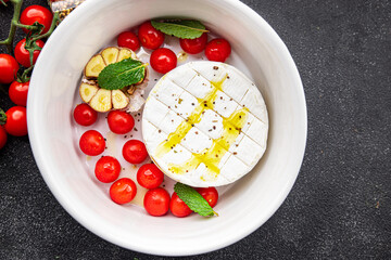 cheese baked Brie or Camembert, tomato, garlic and herbs healthy meal food snack on the table copy space food background rustic top view