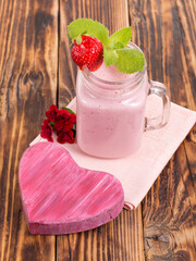 strawberry smoothie with yogurt on a wooden background.
