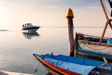 Laguna di Venezia. Barca da pesca con palo e motoscafo