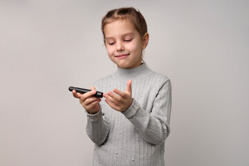Child girl checking blood sugar level, white background