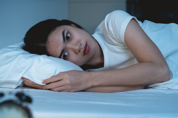 Close-up alarm Young Asian woman have insomnia on the bed