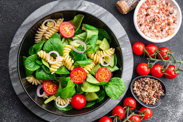 pasta green salad Fusilli, tomato, cucumber, green leaf mix salad, healthy meal food snack on the table copy space food background rustic top view