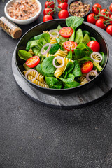 pasta green salad Fusilli, tomato, cucumber, green leaf mix salad, healthy meal food snack on the table copy space food background rustic top view