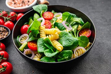 pasta green salad Fusilli, tomato, cucumber, green leaf mix salad, healthy meal food snack on the...