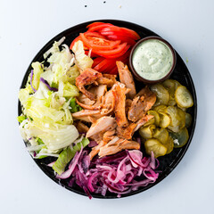 Chicken with tomatoes, lettuce, pickled cucumbers and sauce.
