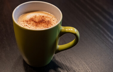 a green cup with cappuccino