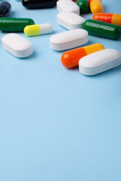 Front view of different pills on blue background,vertical banner with negative space.