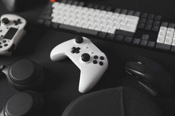 gamer work space concept, top view a gaming gear, mouse, keyboard, joystick, and headset on black table background.