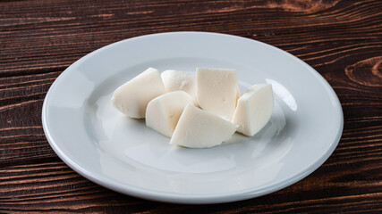 Pieces of Mozzarella cheese in a ceramic plate.