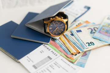 a passport, a flight ticket, differnt currencys on a white surface.