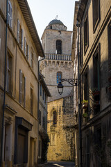 Fototapeta na wymiar Clocher de l'Eglise Saint-Martin depuis la Rue du Séminaire, dans le quartier médiéval du Méjan à Arles