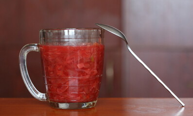 Borscht is poured into a glass beer mug