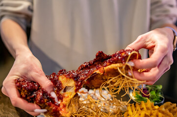 hungry woman hand holding and eatting fried chicken meat in pub