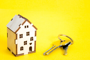 a small house on a yellow background with keys. mortgage. credit. buying a home. realtor