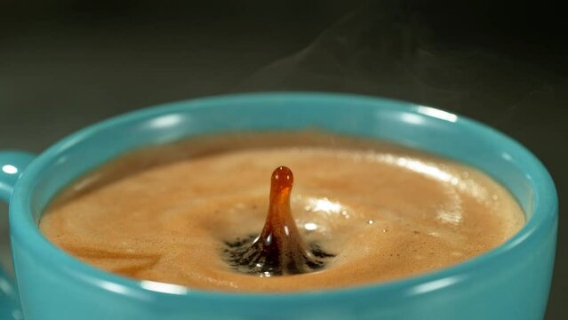 Super Slow Motion Detail Shot of Coffe Drop Falling into Fresh Espresso at 1000 fps.