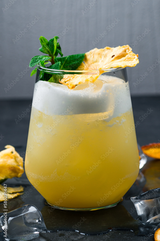 Poster Alcoholic cocktail Almond Whiskey Sour from whiskey, amaretto liqueur, egg white, lemon juice and syrup garnished with mint and dried pineapple slice in a glass.