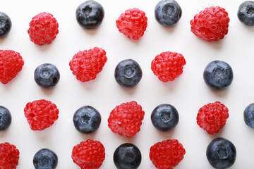 pattern of fresh blueberries and raspberries on a white background