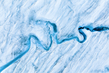 An aerial view of an iceberg and river. Winter landscape from a drone. View of the moraines. Landscape from the air. River on a moraine. - 580292403