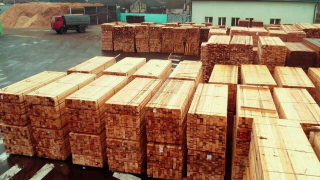 Stacks of commercial timber, at the sawmill. Export of timber on an industrial scale. Wooden board at the marshalling yard. Shooting from a copter.