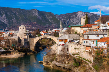 Fototapeta na wymiar A bridge over the Neretva river with a mountain in the background, Mostar, Bosnia and Herzegovina