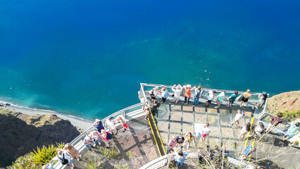 Tourists enjoy the viewpoint at Cabo Girao, along the Madeira coastline, Portugal. Aerial view from...