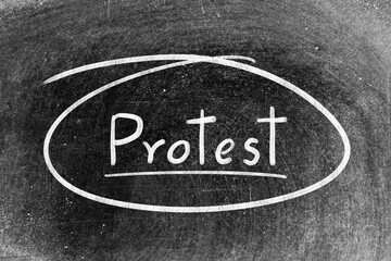 White chalk hand writing in word protest and circle shape on blackboard background