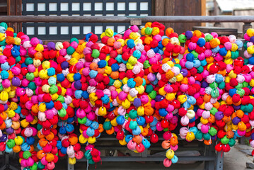  Multi-coloured kukurizaru balls at a temple in Kyoto  in Japan