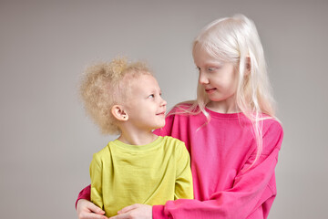 elder sister takes care of her pretty adorable little sister, looking at her with love, tenderness, close up portrait.isolated white background