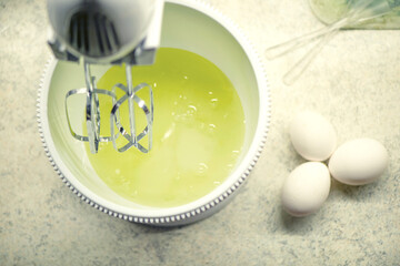 The process of whipping egg whites with a hand mixer. Process of making biscuit. Homemade cakes