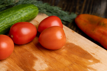Ripe red tomatoes on a wooden chopping board