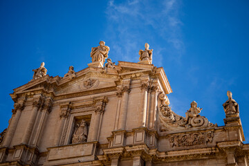 Fototapeta premium Upper part of the monumental facade of the Collegiate Church of San Patricio in Renaissance style and profusely decorated with sculptures from Lorca, Murcia, Spain