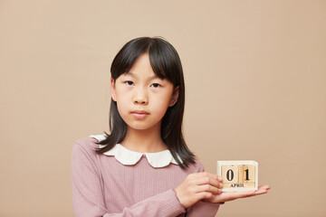 木製のブロックカレンダーを持ている小学生の女の子の様子