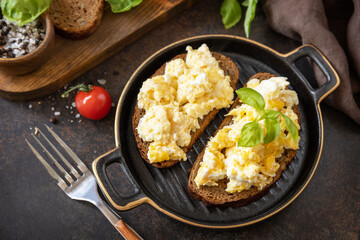 Scrambled eggs on whole grain bread. Homemade breakfast or brunch meal - scrambled eggs.