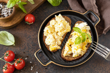Scrambled eggs on whole grain bread. Homemade breakfast or brunch meal - scrambled eggs.