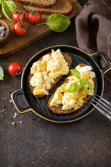 Scrambled eggs on whole grain bread. Homemade breakfast or brunch meal - scrambled eggs. Copy space.