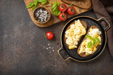 Scrambled eggs on whole grain bread. Homemade breakfast or brunch meal - scrambled eggs. View from above. Copy space.
