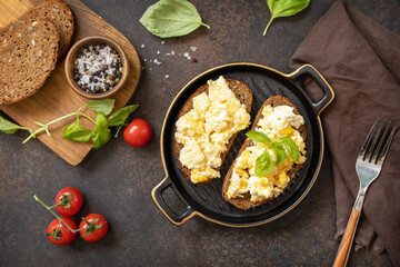 Scrambled eggs on whole grain bread. Homemade breakfast or brunch meal - scrambled eggs. View from above.