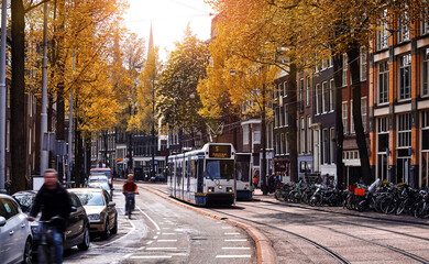 Amsterdam, Netherlands. Street view, Modern tram, public transport moving by Autumn evening sunny...