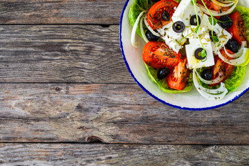 Fresh vegetable salad with feta cheese on wooden table
