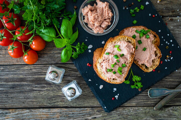 Tasty sandwiches with liverwurst and chive on wooden table
