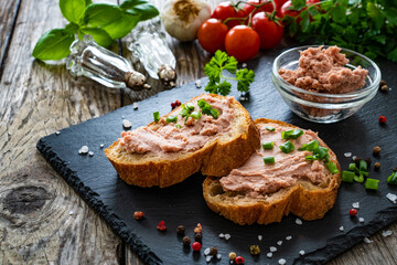 Tasty sandwiches with liverwurst and chive on wooden table

