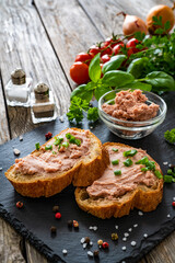Tasty sandwiches with liverwurst and chive on wooden table
