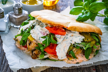 Kebab - grilled meat, bread and vegetables on wooden table
