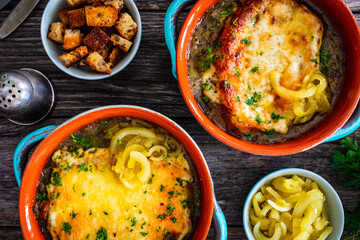 Onion soup with roasted bread with cheese on wooden table
