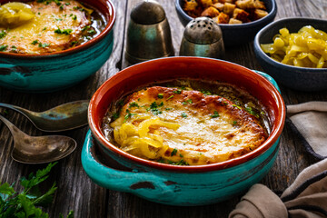Onion soup with roasted bread with cheese on wooden table
