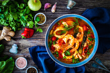 Seafood and fish soup on wooden table
