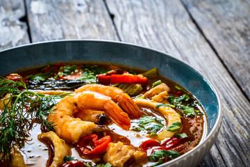 Seafood and fish soup on wooden table
